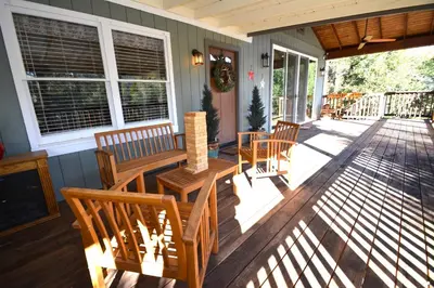 a porch with a table and chairs on a house at Ledge House-Lake Area Free Night Special in Bass Lake
