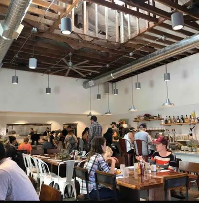 a group of people sitting at tables in a restaurant at Artist's Condo with 2 Bedroom & Arcade in Sacramento