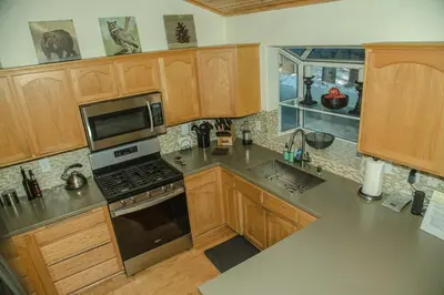 a kitchen with wooden cabinets and a stove top oven at Cozy 3 bedroom home in Tahoe Donner in Truckee