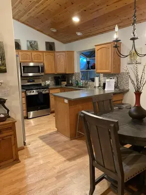 a kitchen with wooden cabinets and a table with chairs at Cozy 3 bedroom home in Tahoe Donner in Truckee
