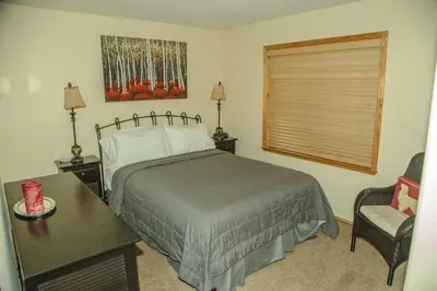 a bedroom with a bed and a chair and a window at Cozy 3 bedroom home in Tahoe Donner in Truckee