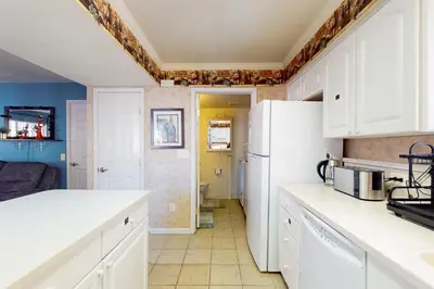 a kitchen with white cabinets and a white refrigerator at Wildwood Wonder in South Lake Tahoe