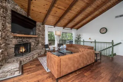 a living room with a couch and a fireplace at Yosemite Lookout Lodge w/ hot tub, firepits, game room, and more in Oakhurst