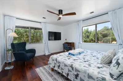 a bedroom with a bed and a ceiling fan at Yosemite Lookout Lodge w/ hot tub, firepits, game room, and more in Oakhurst