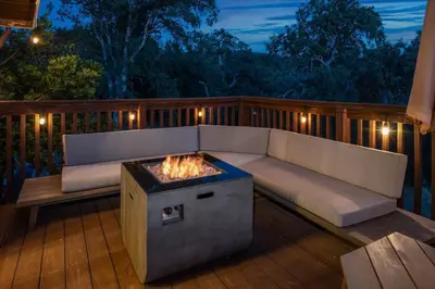 a patio with a couch and a fire pit on a deck at Yosemite Lookout Lodge w/ hot tub, firepits, game room, and more in Oakhurst