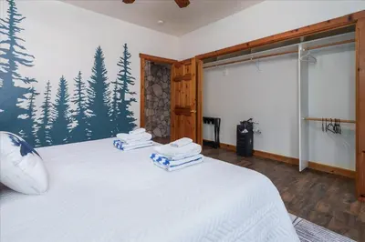 a bedroom with a bed with towels on it at Cedar Creek Lodge with POOL/hot tub/sleeps 24 in Oakhurst