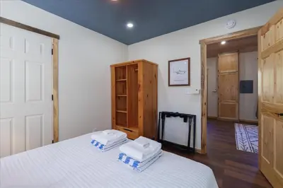 a bedroom with a bed with two towels on it at Cedar Creek Lodge with POOL/hot tub/sleeps 24 in Oakhurst