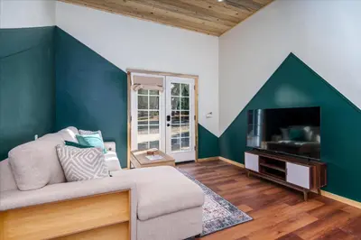 a living room with a couch and a flat screen tv at Cedar Creek Lodge with POOL/hot tub/sleeps 24 in Oakhurst