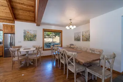 a dining room with a wooden table and chairs at Greystone Manor- HUGE home with sleeping for 21 in Oakhurst