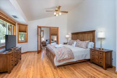 a bedroom with a bed and a flat screen tv at Greystone Manor- HUGE home with sleeping for 21 in Oakhurst