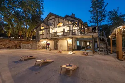 a large house with benches in front of it at Greystone Manor- HUGE home with sleeping for 21 in Oakhurst