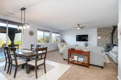 a living room with a table and a couch at Hilltop Paradise with stunning views/hot tub/firepit/dog friendly in Oakhurst