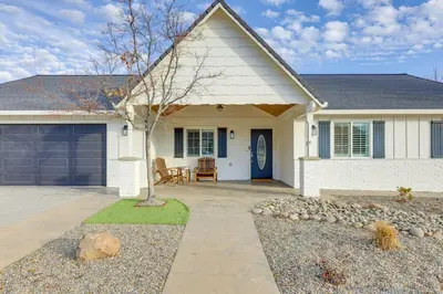a white house with a blue door at Walk Downtown Remodeled Home in Murphys with Yard! in Murphys