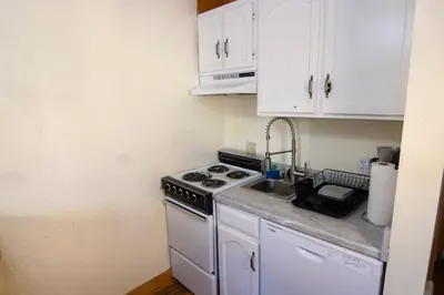 a kitchen with a stove and a sink and white cabinets at Inside Yosemite Park-Cozy Corner Unit-Sleeps 2 in Yosemite West