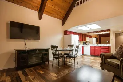 a living room with a table and a flat screen tv at North Lake Lodges & Villas in Incline Village