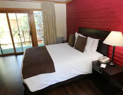 a bedroom with a large bed with a red wall at North Lake Lodges & Villas in Incline Village