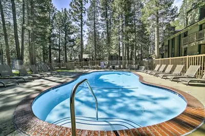 a large swimming pool with lounge chairs and trees at Sunshine Village #108- 1 +Loft , Sleeps 6. Steps from Free Town Shuttle ,Dog Friendly in Mammoth Lakes