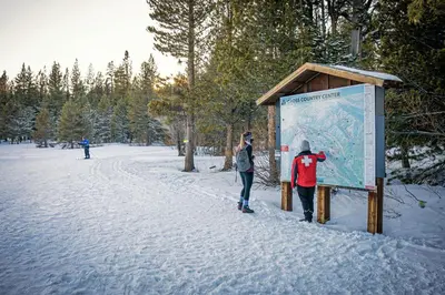 a man and a woman standing next to a sign in the snow at Donner Gem by Tahoe Getaways - Beautifully Updated, Hot Tub, Pet Friendly in Truckee