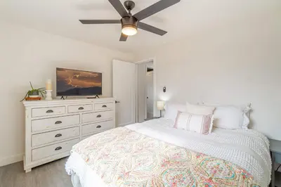 a bedroom with a bed with a ceiling fan and a dresser at Cozy Family Haven in Sparks - Pet Friendly - Fenced Yard in Sparks