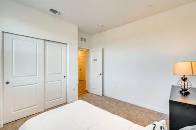 a bedroom with white walls and a bed and a desk at 15 Mi to Dtwn Sacramento Newly Built Home! in Sacramento