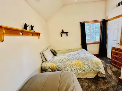 a bedroom with a bed and a dresser and a window at Cozy Bear South-Inside Yosemite-Sleeps 5 in Yosemite West