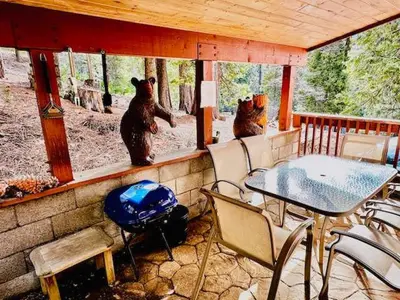 three bears sitting on a porch with a table and chairs at Cozy Bear South-Inside Yosemite-Sleeps 5 in Yosemite West