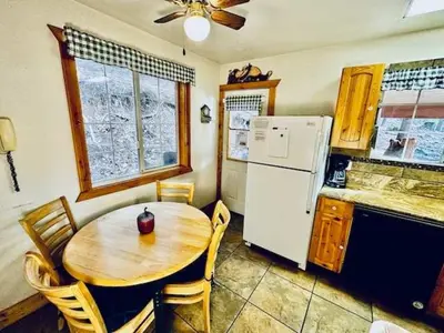 a kitchen with a wooden table and a white refrigerator at Cozy Bear South-Inside Yosemite-Sleeps 5 in Yosemite West