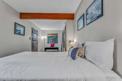 a bedroom with a large white bed with pillows at Kings Beach Cabin Private Hot Tub, Near Lake & Ski in Kings Beach