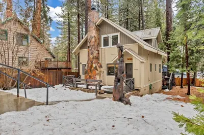 a house in the woods with a statue in the snow at Kings Beach Cabin Private Hot Tub, Near Lake & Ski in Kings Beach
