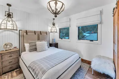 a bedroom with a bed and a chandelier at Cozy Carnelian Bay Vacation Rental with Lake Views in Carnelian Bay