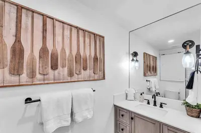 a white bathroom with a sink and a mirror at Cozy Carnelian Bay Vacation Rental with Lake Views in Carnelian Bay
