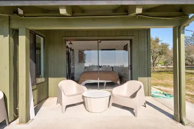 a screened in porch with two chairs and a bed at Rocky Ridge Cabin Yosemite in Coarsegold
