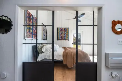 a bedroom with a bed in a glass wall at Rocky Ridge Cabin Yosemite in Coarsegold