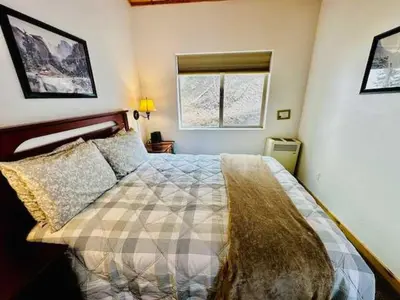 a bedroom with a bed and two windows at Yosemite Woods Duplex in Yosemite-Upper Unit in Yosemite West