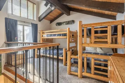 a room with two bunk beds and a staircase at Canyon Slopeside Retreat in Mammoth Lakes