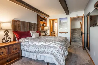 a bedroom with a large bed and a wooden dresser at Canyon Slopeside Retreat in Mammoth Lakes