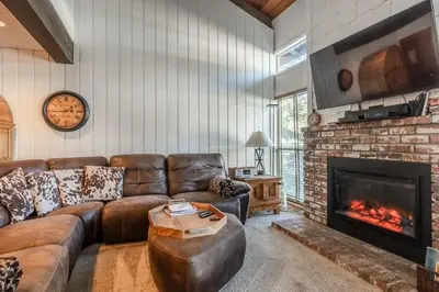 a living room with a couch and a fireplace at Canyon Slopeside Retreat in Mammoth Lakes