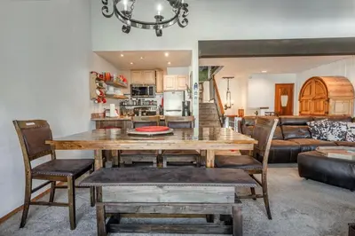 a dining room and living room with a table and chairs at Canyon Slopeside Retreat in Mammoth Lakes