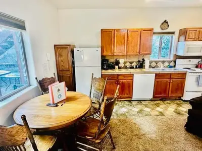 a kitchen with a wooden table and a kitchen with a refrigerator at Lower Unit-Yosemite Woods-Inside Yosemite in Yosemite West