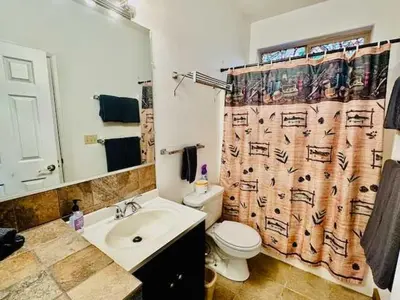a bathroom with a sink and a toilet and a shower curtain at Lower Unit-Yosemite Woods-Inside Yosemite in Yosemite West