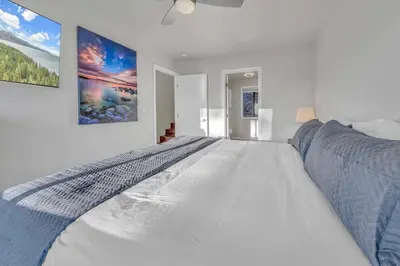 a white bedroom with a large bed in it at Lake Tahoe Vacation Rental Fireplace and Balcony in Incline Village