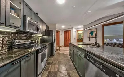 a kitchen with green cabinets and a counter top at Palisades Village ski in ski out Mountain Retreat in Olympic Valley