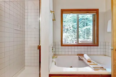 a bathroom with a bath tub and a window at Evergreen Escape in Truckee