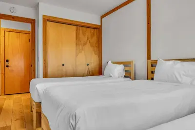 a bedroom with two beds and a wooden door at Cozy Mountain Retreat in Truckee Near Northstar in Truckee