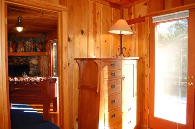 a room with a dresser and a lamp next to a window at Black Oak Lodge at The Redwoods in Wawona