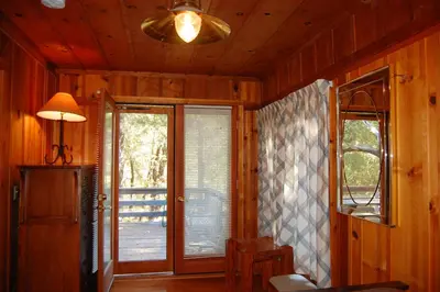 a room with a door and a lamp and a window at Black Oak Lodge at The Redwoods in Wawona