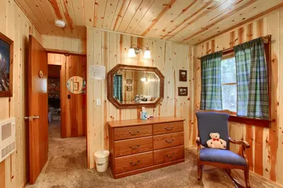 a bathroom with a dresser and a chair and a mirror at Shangri la-de-da at The Redwoods in Wawona