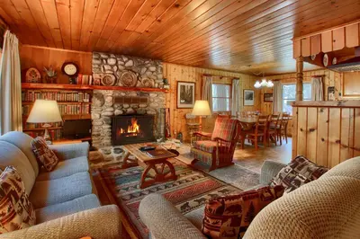 a living room with a fireplace and a dining room at Shangri la-de-da at The Redwoods in Wawona