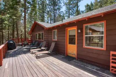 a wooden deck with chairs and a house at Shangri la-de-da at The Redwoods in Wawona