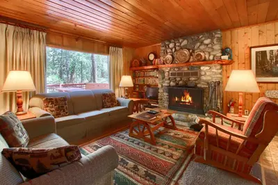 a living room with a couch and a fireplace at Shangri la-de-da at The Redwoods in Wawona